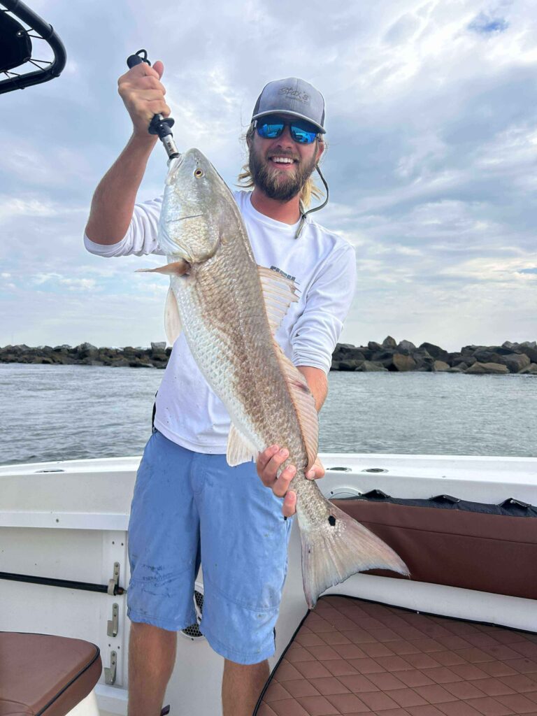 Angler holding a flounder catch on a fishing charter in Murrells Inlet South Carolina