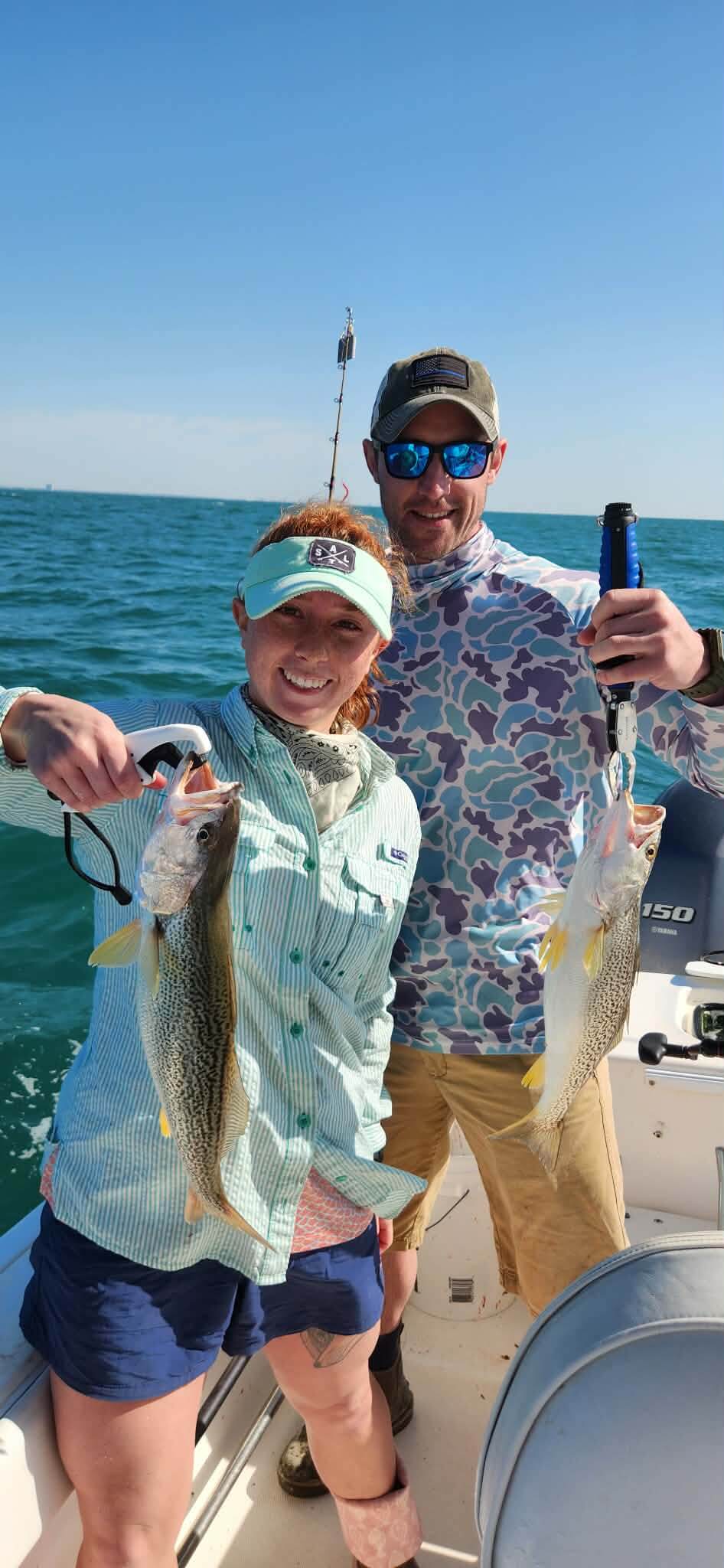 Couple holding two speckled trout on a fishing charter in Murrells Inlet South Carolina