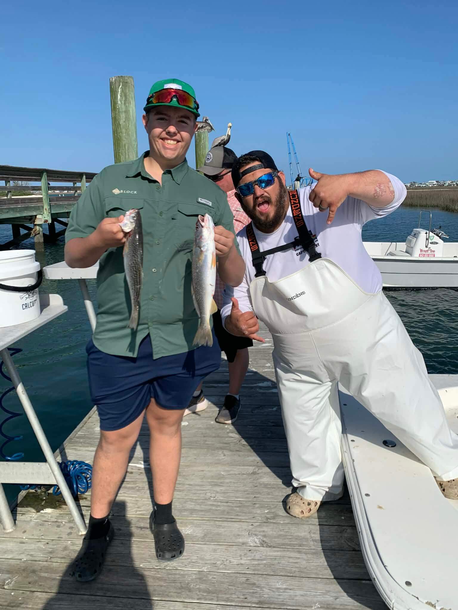 Anglers holding speckled trout on a nearshore fishing charter in Murrells Inlet South Carolina
