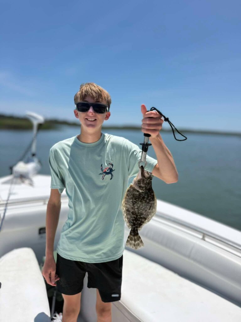 Young angler holding flounder on a Murrells Inlet fishing charter