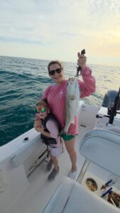 Family enjoying a fishing trip in Murrells Inlet after catching a redfish