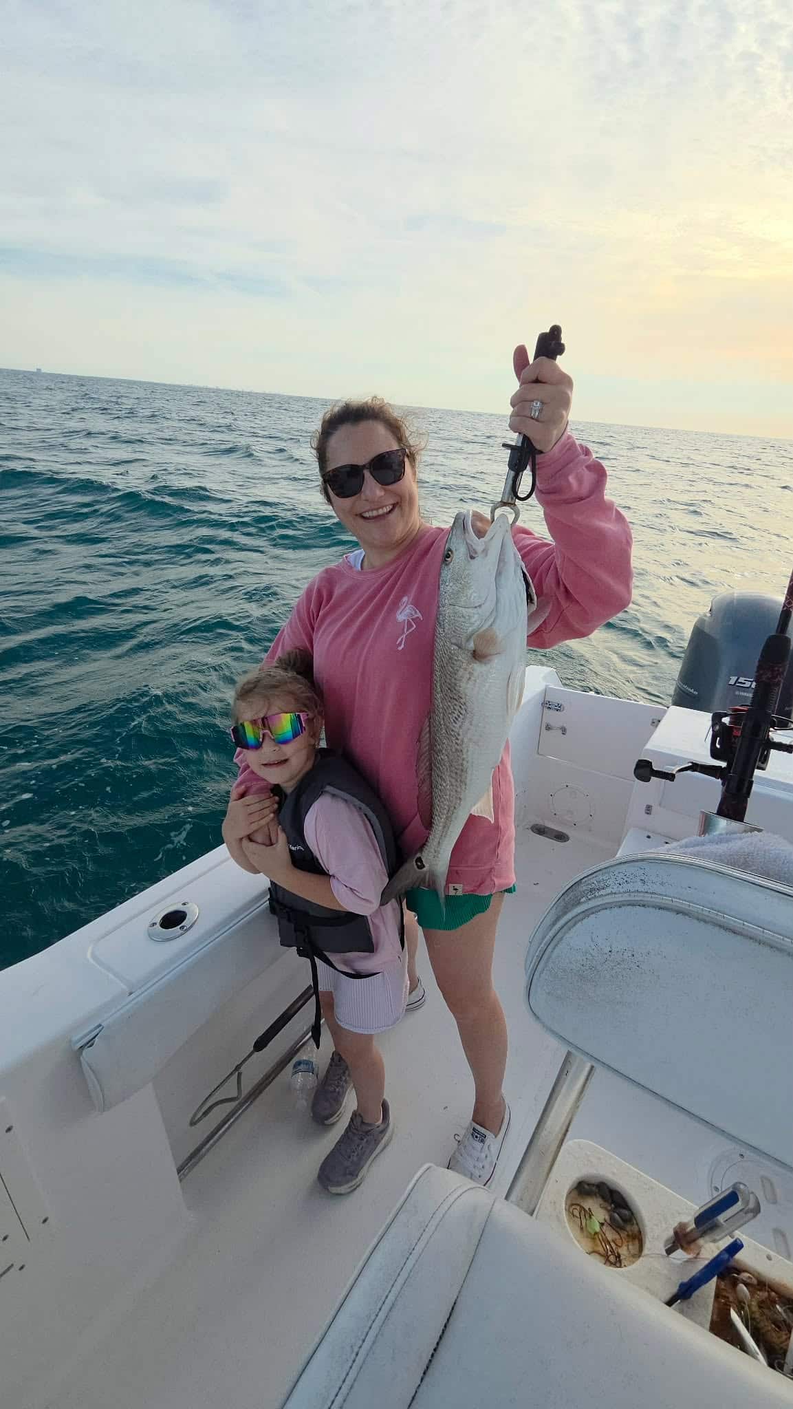 Family enjoying a fishing trip in Murrells Inlet after catching a redfish