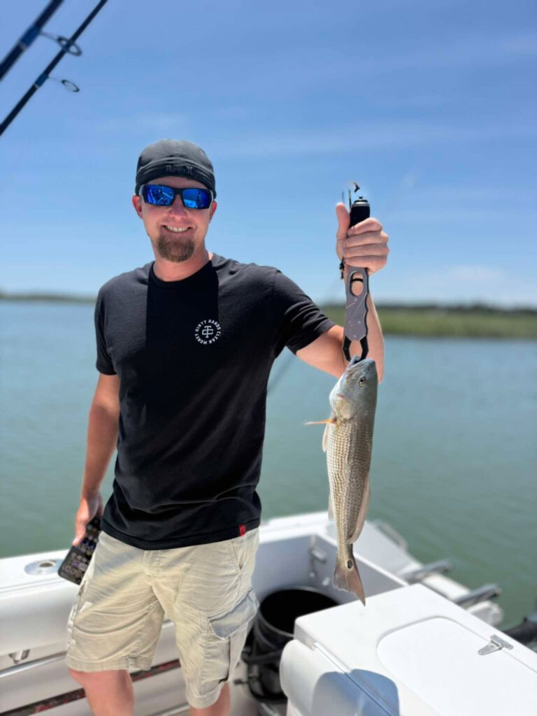 Angler holding redfish during an inshore fishing charter in Murrells Inlet