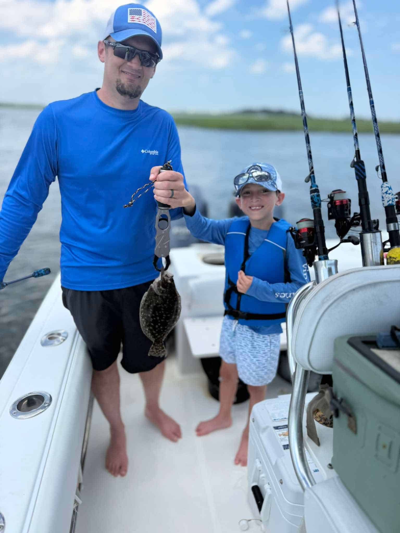 Adult and child holding a flounder on a summer fishing charter in Murrells Inlet