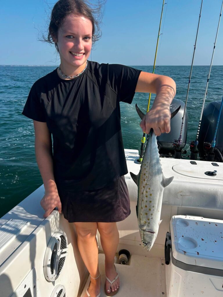 Angler holding a Spanish mackerel on a fishing boat off Murrells Inlet