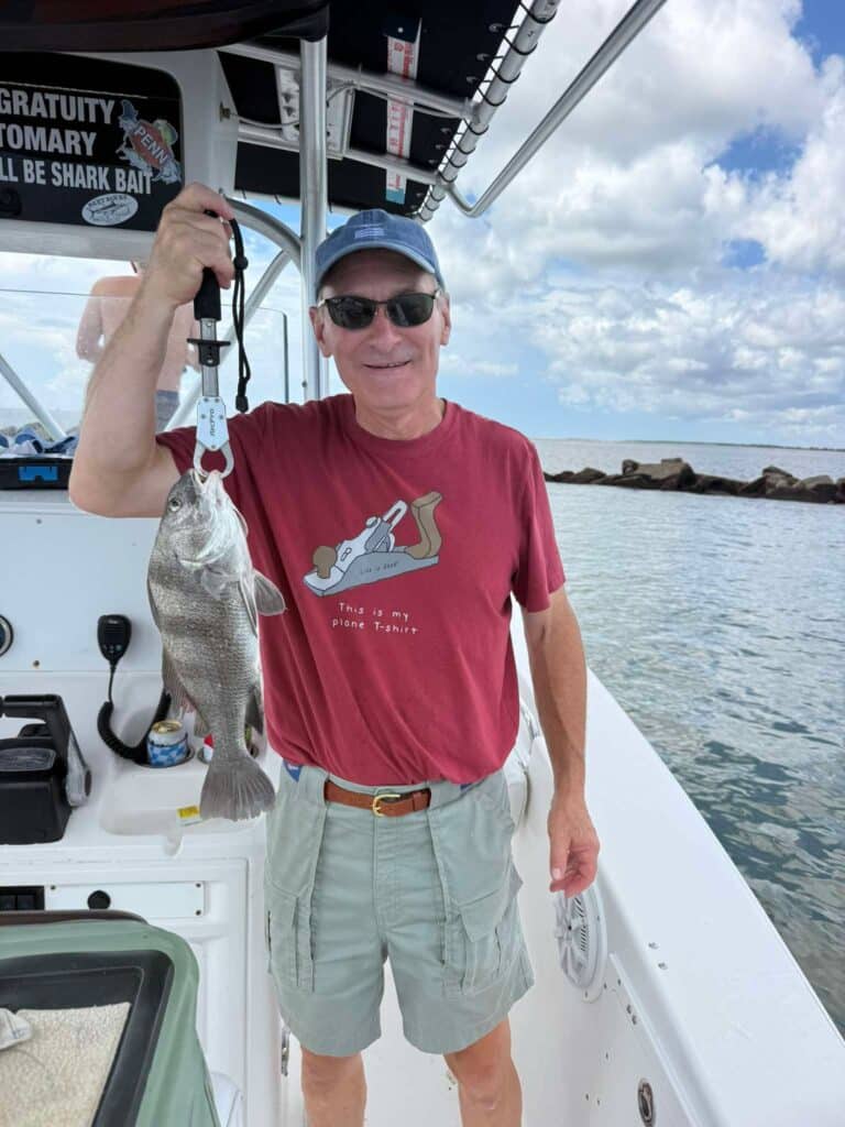 Angler holding a black drum during a fishing trip in Murrells Inlet