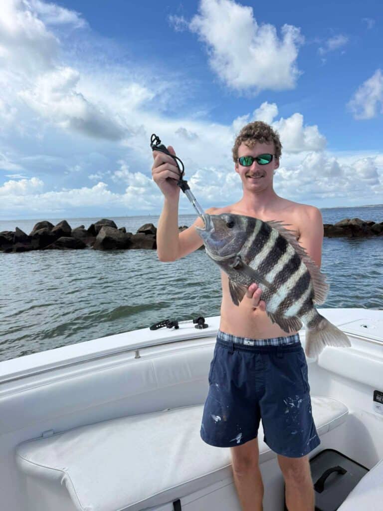 Young angler holding a large sheepshead on a fishing boat near the Murrells Inlet jetties