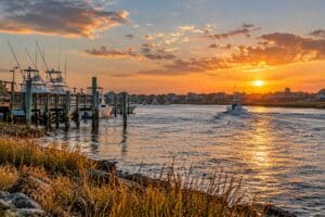 Golden-hour sunset over Murrells Inlet with boats, docks, and waterfront homes